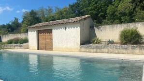 Una piscina amb un edifici petit al costat.