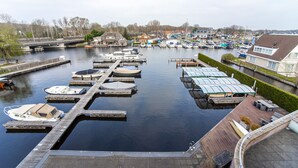 Ein Yachthafen mit mehreren Stegen und Booten, umgeben von Wohnhäusern und einer Brücke im Hintergrund.