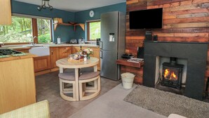 Eine moderne Küche mit Einbauherd, Holzschränken und einem Essbereich mit rundem Tisch und Stühlen.
