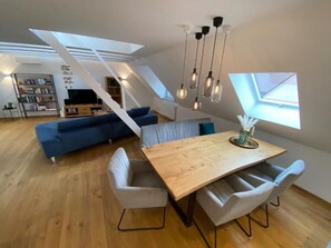 Un espace de vie moderne de style loft, comprenant un coin repas, un canapé et un téléviseur.