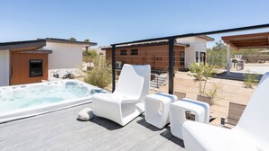 A rooftop terrace with a hot tub, white lounge chairs, and a wooden pergola. - Contemporary Compound By Homestead Modern (Joshua Tree)