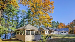 A lakeside cabin with a covered porch and a separate building with a large porch. - Hideaway at Highland Lake (Andover)