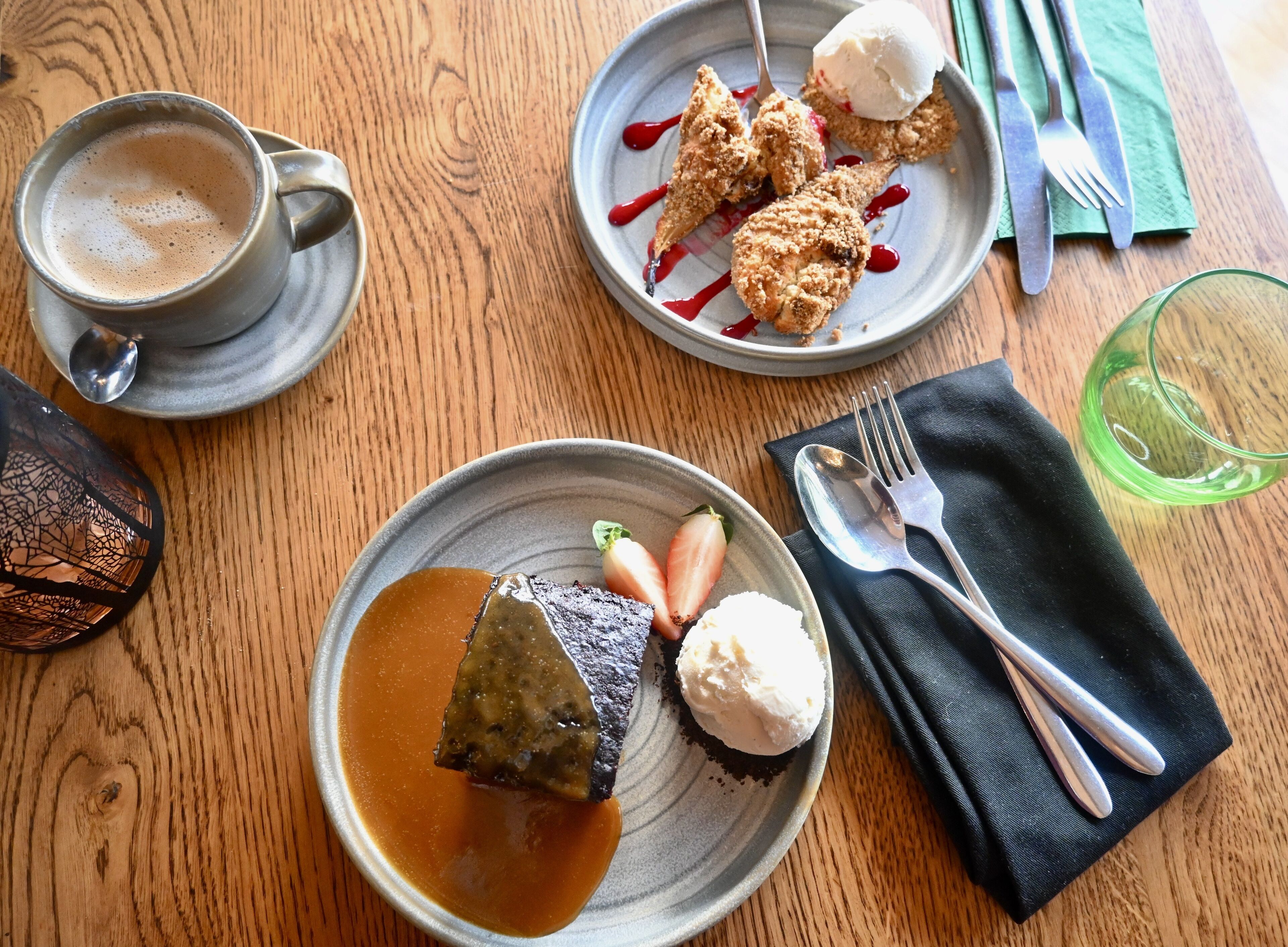 A table with a plate of food, a cup of coffee, and cutlery.