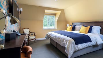 Un dormitorio con una cama grande, un escritorio con lámpara, una silla y una ventana con persianas.