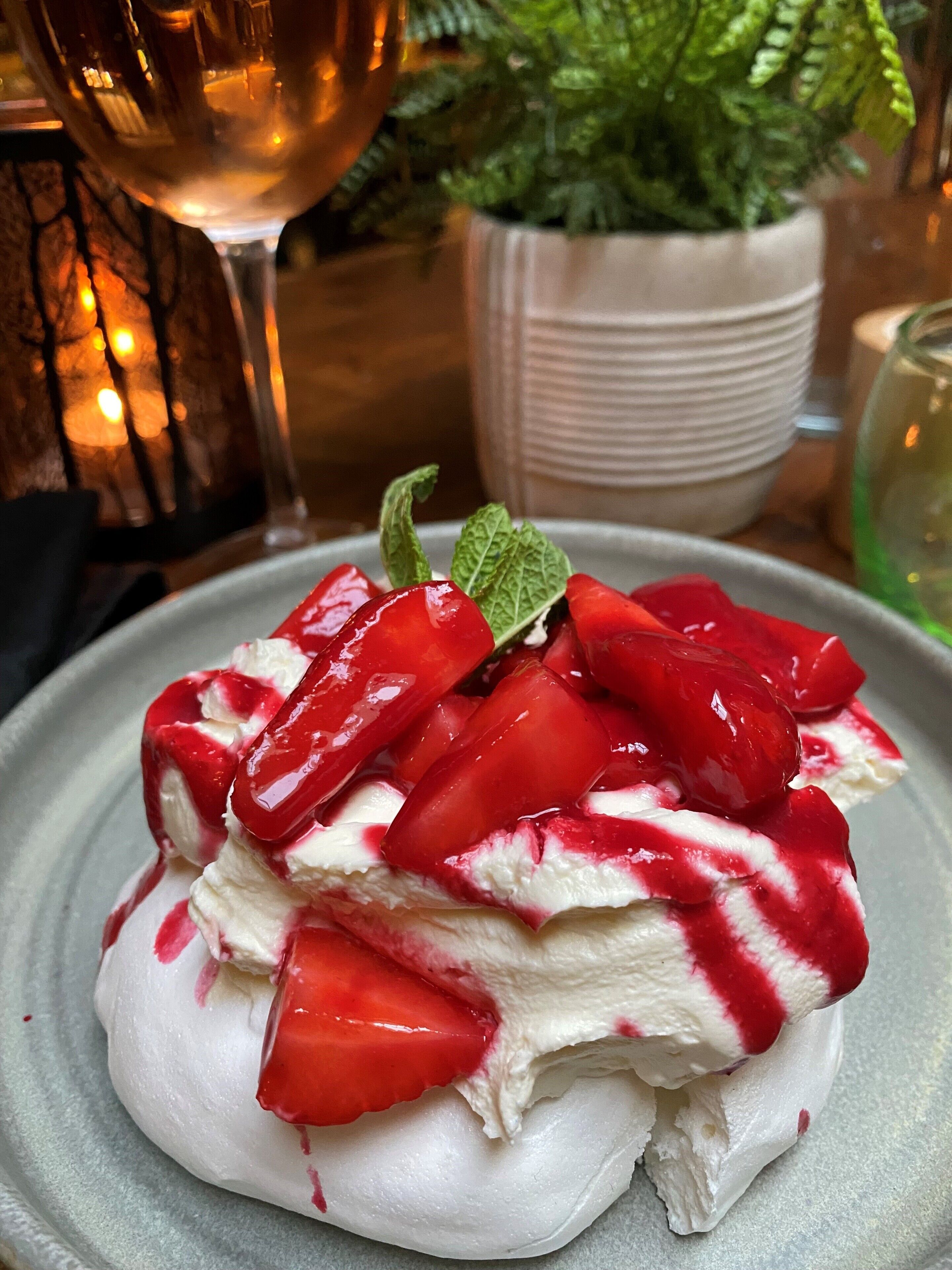 Ein Dessert mit Erdbeeren und Schlagsahne auf einem Teller.