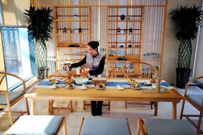 Un comedor con una mesa de madera dispuesta para una comida, rodeado de sillas.
