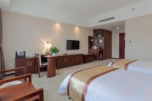 A hotel room with two beds, a desk with a chair, a TV, a bookshelf, and a plant. - Nanshanyuan Hotel (Xi'an)