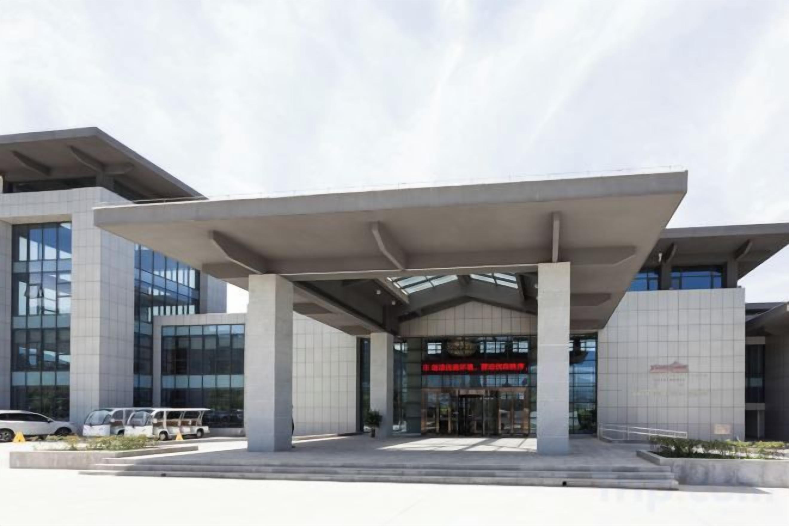 A modern building with a covered entrance and large windows.