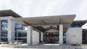 A modern building with a covered entrance and large windows.