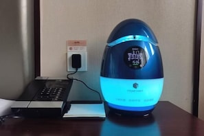 A blue air purifier with a digital display, connected to a power outlet, and a keyboard on a desk. - Nanshanyuan Hotel (Xi'an)