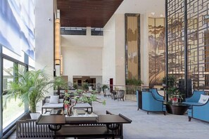 A spacious lobby with high ceilings, seating areas, and a large decorative wall. - Nanshanyuan Hotel (Xi'an)