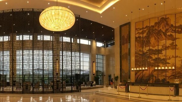 A spacious lobby with a large chandelier, a traditional mural, and a seating area. - Nanshanyuan Hotel (Xi'an)
