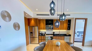 A modern kitchen with a central island, stainless steel appliances, and pendant lighting. - NEW large balcony, hot tub, gym (Puerto Vallarta)