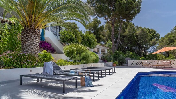 A poolside area with lounge chairs, a palm tree, and a tiled pool. - Villa CORASOL by Abahana Villas (Teulada)
