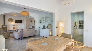A spacious living area with a wooden dining table, comfortable seating, and a television. - Villa CORASOL by Abahana Villas (Teulada)