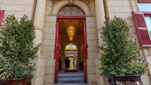 A grand entrance with a staircase leading to a door, flanked by large potted plants. - Palazzo Pisani Malta Boutique & Spa (Zabbar)