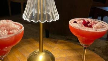 Une table avec deux boissons, une lampe et une boîte en bois.