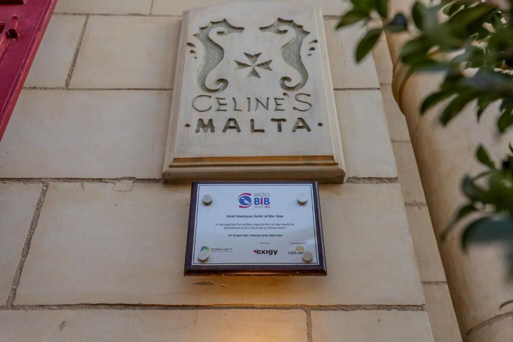 Una placa en un edificio con el texto 'CELINE'S MALTA' y 'MEJOR HOTEL DE MALTA DEL AÑO'.