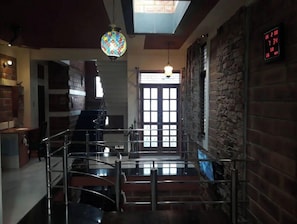 Stunning multi-level space with a staircase, brick wall, and colorful stained glass window.