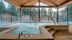 A hot tub area with a wooden ceiling, stone steps, and metal railings. - Trails End Mountainview Penthouse Condo: Ski In/Out, Stroll To Main Street (Breckenridge)