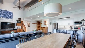 A modern kitchen with white cabinets, stainless steel appliances, and a wooden dining table. - Trails End Mountainview Penthouse Condo: Ski In/Out, Stroll To Main Street (Breckenridge)