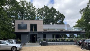 A modern hotel with a two-story structure, a covered outdoor seating area, and a parking lot. - Zweirad Hotel Lenne (Schwerin)