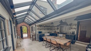 Una cocina amplia con una gran mesa de madera y electrodomésticos modernos.