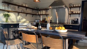 Cocina moderna con armarios oscuros, una isla central e iluminación colgante.