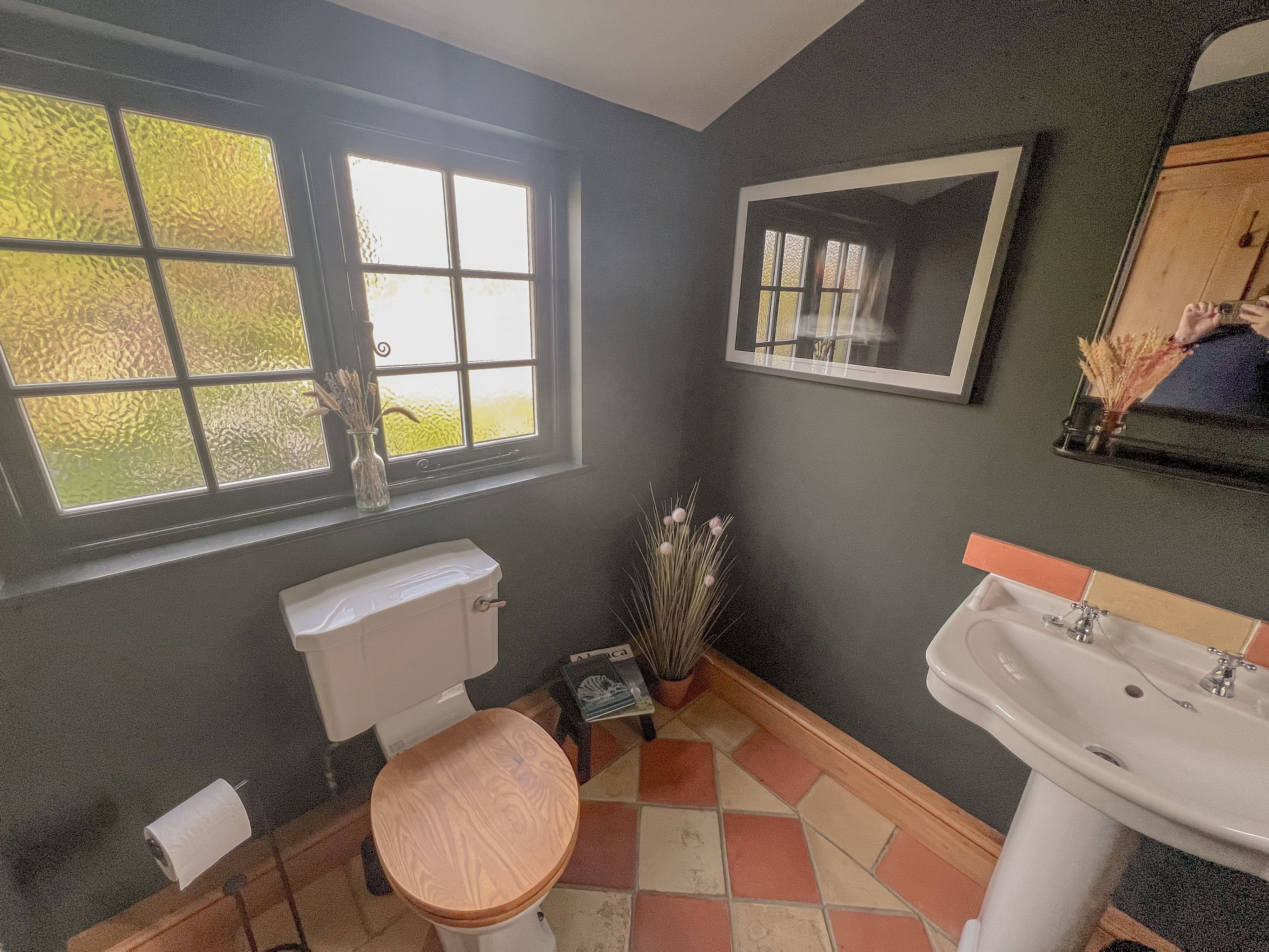 Une salle de bain avec des toilettes, un lavabo et une fenêtre.