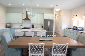 A modern kitchen with light blue cabinets, a central island with seating, stainless steel appliances, and pendant lighting. - North Cape, Private Pool (April26)Gulf View home, pet friendly, VayK Gear! (Port Saint Joe)