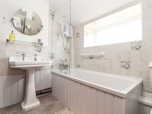 A bathroom with a pedestal sink, a bathtub, a shower, and a window. - Myrtle Cottage (Hayle)