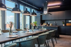 A modern dining area with a long table set for six, surrounded by chairs. - District Living (Vienna)