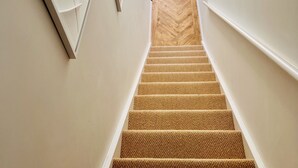 Un interior moderno con una escalera que lleva a un balcón.