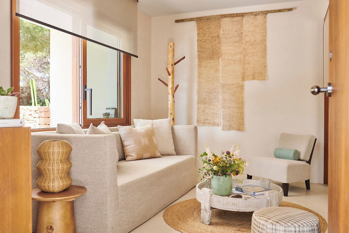 A modern living room with a sofa, armchair, coffee table, and decorative items.