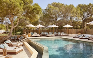 Una piscina al aire libre, tumbonas