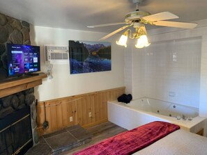 Une salle de bain avec une baignoire, une douche et un ventilateur de plafond.