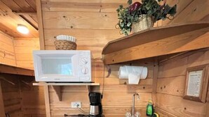 A compact kitchen with wooden walls, a microwave, a coffee maker, and a sink. - Unique 1 BDRM with Jetted Hot Tub - Bear Manor #5 (Big Bear Lake)