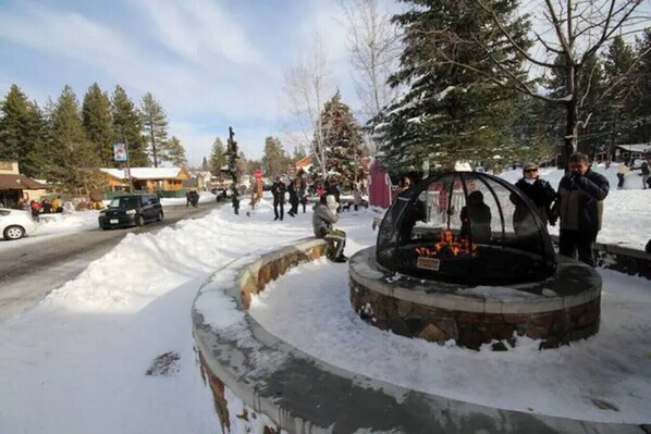Zona exterior nevada con una estructura circular de piedra, posiblemente una fuente o adorno decorativo, rodeada de nieve.