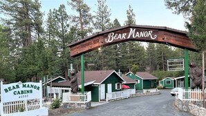 Les chalets de Bear Manor se distinguent par leur entrée en forme d’arche en bois, leur couleur verte et leur clôture blanche en piquets.