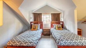 A bedroom with two beds, a window with curtains, a nightstand, and a wooden wardrobe. - Spacious, Fun Family Cabin - Cozy Hollow Lodge #2 (Big Bear Lake)