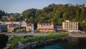 Une ville riveraine dotée de bâtiments historiques, d’un pont et d’une colline boisée.