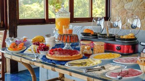 Una mesa de buffet con diferentes platillos y ponche de frutas.