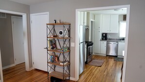 A modern kitchen with stainless steel appliances, wooden flooring, and a built-in bookshelf. - 1742 Uptown | 3 bed, walk to Mayo St Marys Campus! (Rochester)