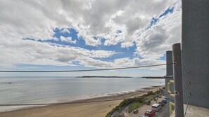 Une vue côtière avec une plage, un ciel dégagé et un bâtiment desservi par une ligne de téléphérique.
