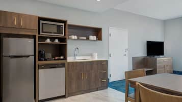 Una cocina moderna con microondas integrado, refrigerador de acero inoxidable y armarios de madera.