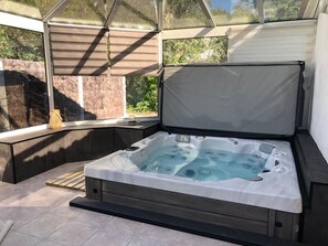 A hot tub in a covered outdoor area with a view of greenery. - Fully Equipped Villa—direct access to the beach, just a 3-minute walk away, and close to shops (L'Épine)