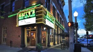 Un bâtiment en briques avec une enseigne lumineuse au néon indiquant « Bartney's Seafood Bar », situé sur la place du centre-ville d'Ocala.