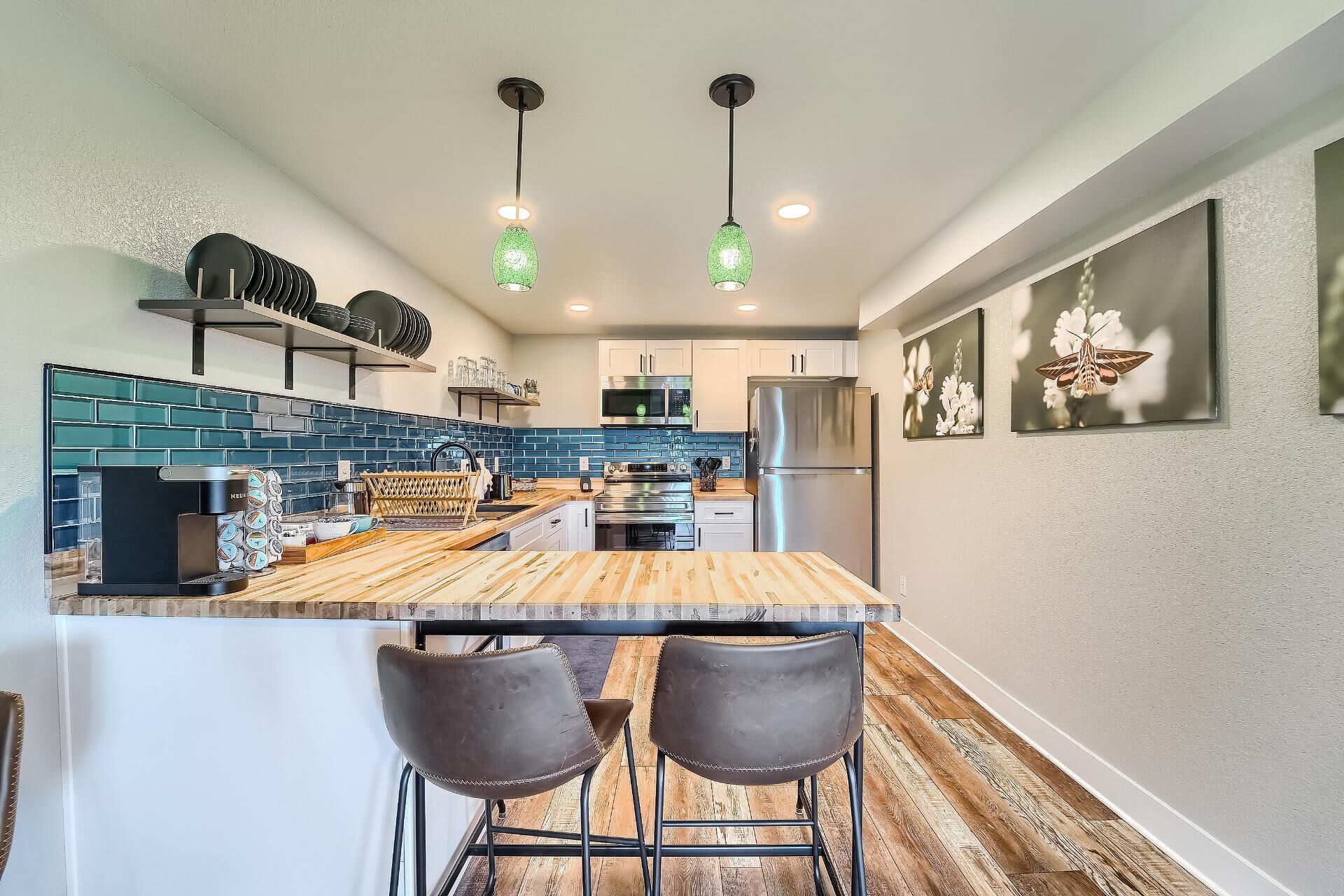 A modern kitchen with a central island, stainless steel appliances, and a bar area with stools.
