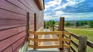 A wooden deck with a metal grate, leading to a grassy area with a view of houses and mountains. - Grandview Hideaway - Vast views, walk to restaurants, disk golf, lots of privacy (Erie)