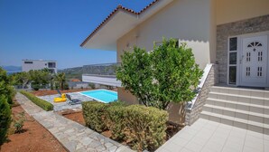 Una casa moderna con piscina, escalera y vista al mar.